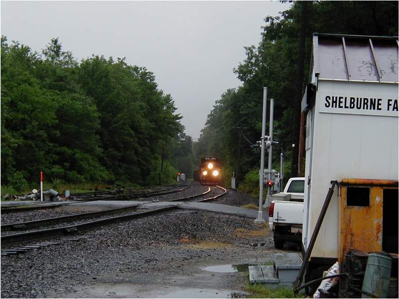 Photo of An empty string of coal hoppers returns from Mt. Tom approaching Shelburne Falls