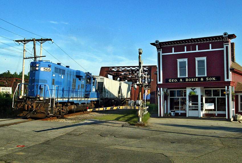 Photo of New England Southern passing Robie's store