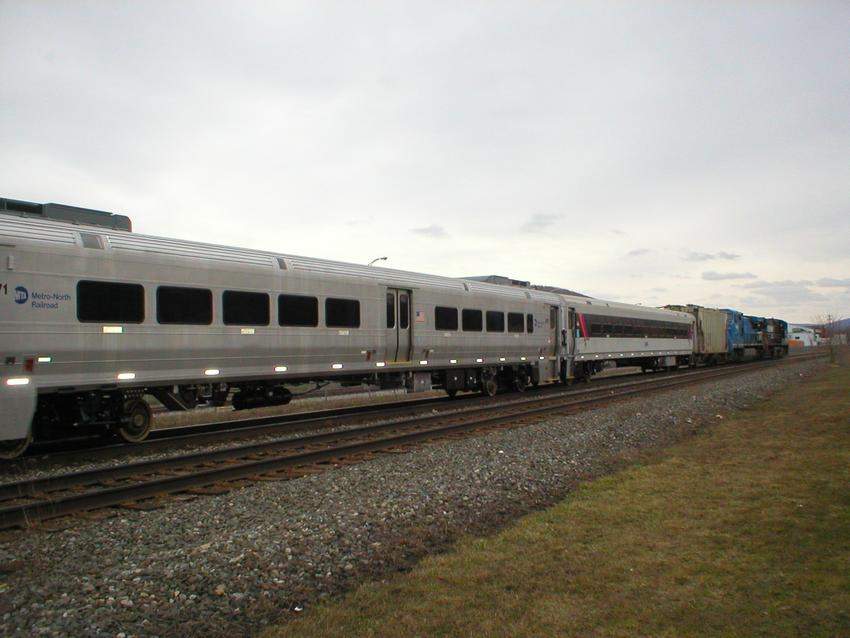Photo of new Metro-North Comet cars and a rebuilt NJT car heading off.