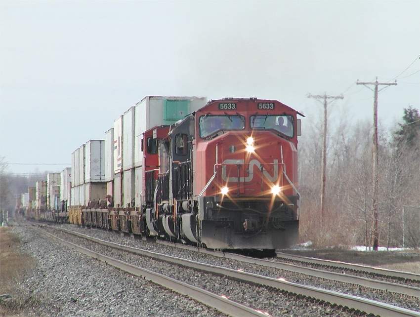 Photo of CN 5633 leads intermodal 148 eastbound at St Hilaire, Quebec.