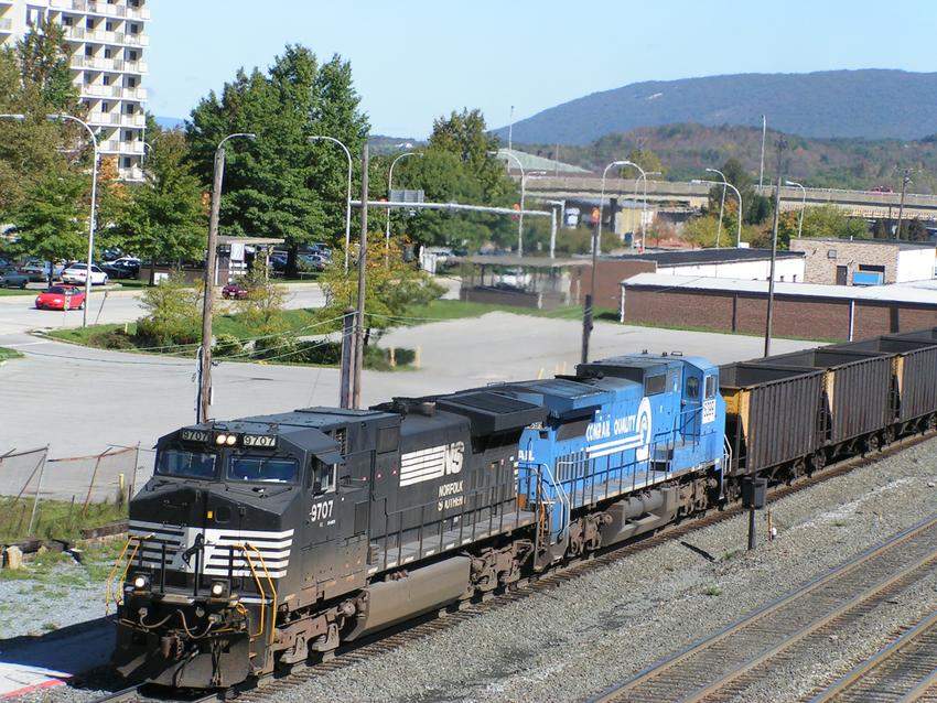 Photo of NS 9707 & X Conrail 8399 pull a line of empty coal hoppers west