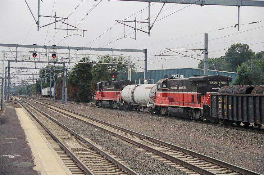 Photo of 3902 and 2201 sandwich a tank between them as they lead NH-1 west