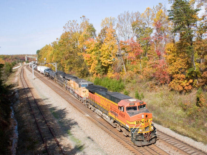 Photo of BNSF 4997 pull a NS train southbound through Revillo, KY.