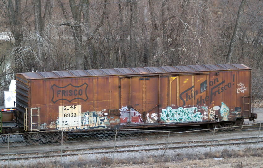 Photo of Frisco boxcar on its way to the scrap heap.