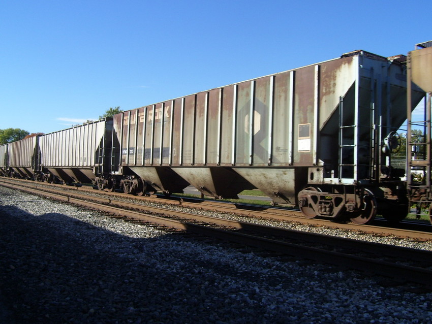 Photo of An old Rock Island grain hopper was in mid-consist of this Grain Train.