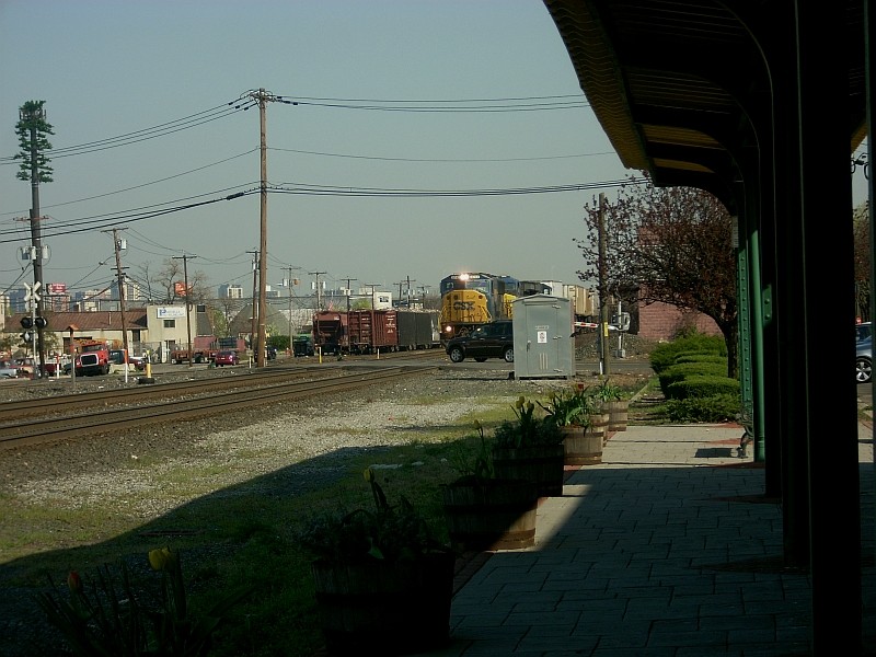 Photo of a car on CSX mainline just as a freight is passing on the seccond track.