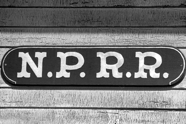 Photo of 2 of 4, OLD PAINT, NPRR  sign on Peace Dale Station, 1974