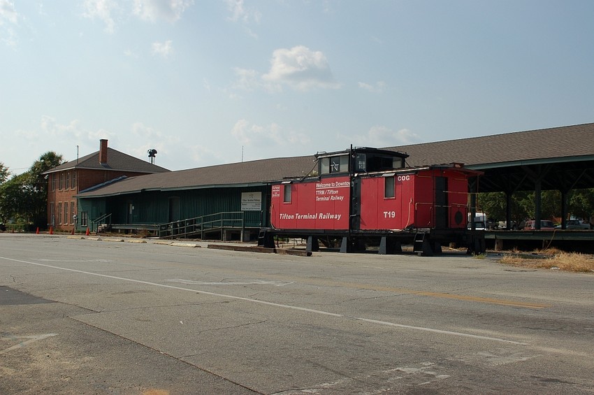 Photo of TFTX Caboose No. T19 and former SCL Passenger Station