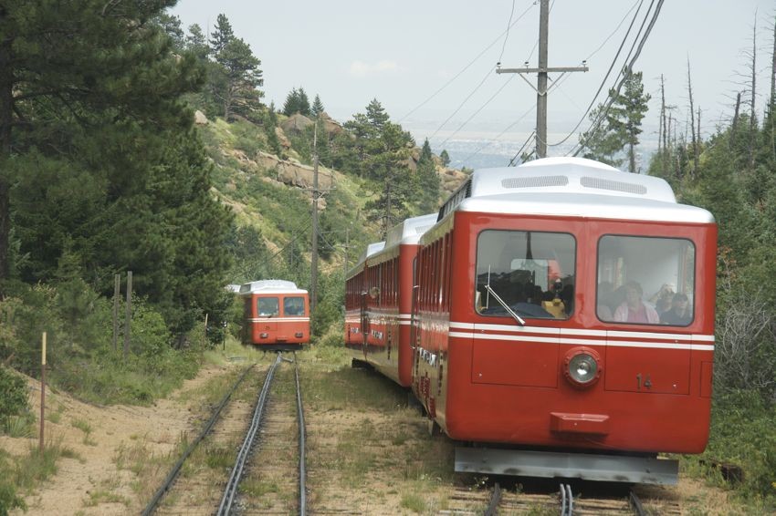 Photo of Two Pikes Peak Cog Railway trains pass on the mountain.