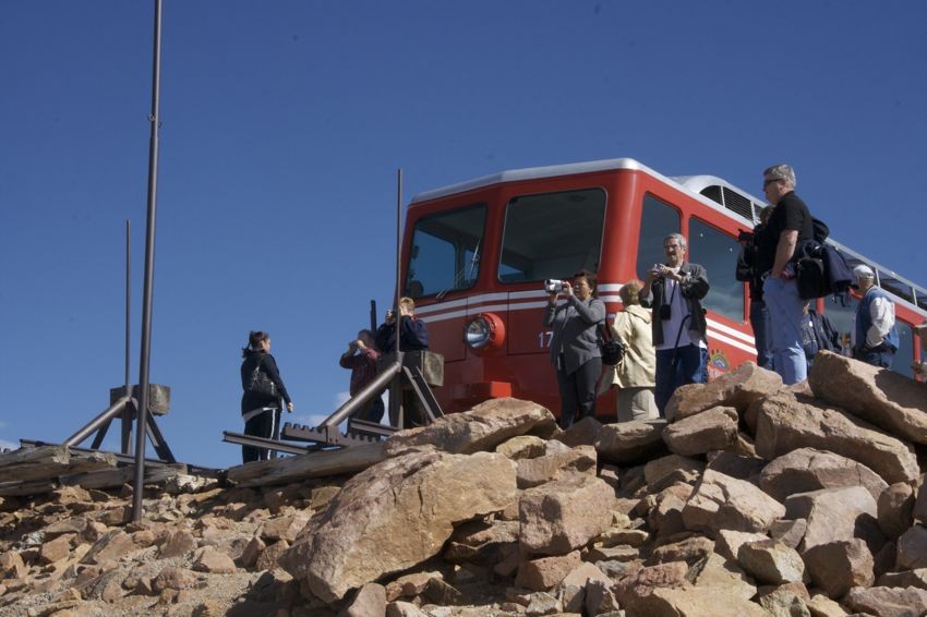 Photo of People stand at the end of the tracks at the summit of Pikes Peak