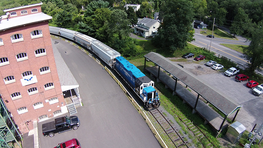 Photo of Mass Central 1750 passes old factory in Thorndike